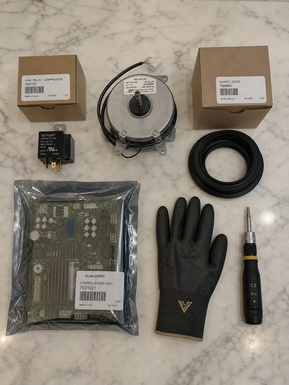 Genuine OEM appliance repair parts laid out before a Sub-Zero repair